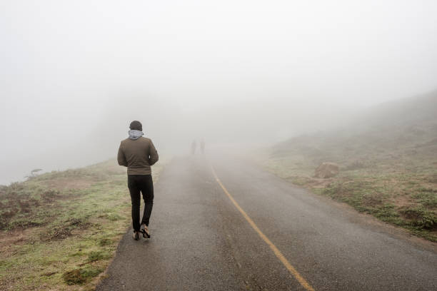 istock Lone man walking through the white fog 675272174