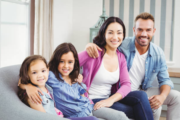 istock Happy parents sitting with children on sofa 675275504