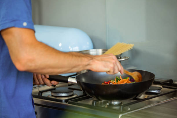 istock Man preparing food in kitchen 675275750