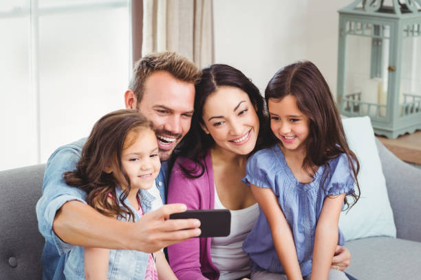 istock Family smiling while taking selfie on mobile phone 675275756