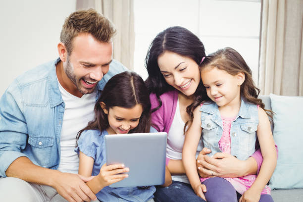 istock Family smiling while looking in digital tablet 675278108