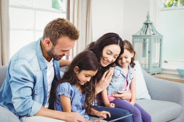 istock Family looking in digital tablet while sitting on sofa 675278200