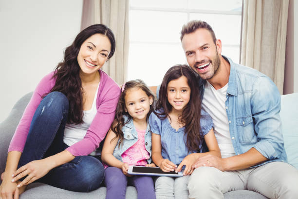 istock Family with tablet computer sitting on sofa 675278276