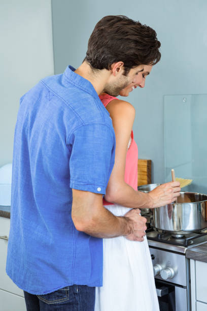 istock Young couple preparing food together in kitchen 675278770