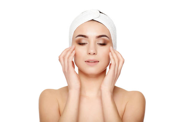 istock Beautiful young woman touching her face on a white background 675292056
