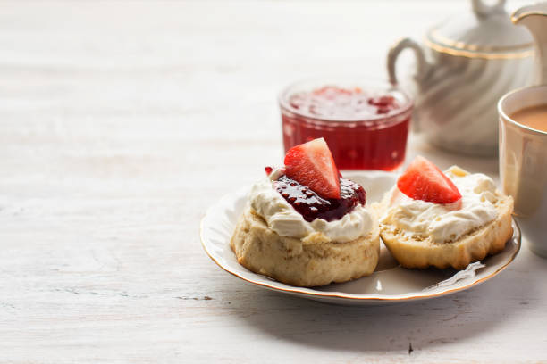 English cream teas with scones English tea with scones and clotted cream, jam, strawberries on the white table, copy space for text, selective focus afternoon tea photos stock pictures, royalty-free photos & images
