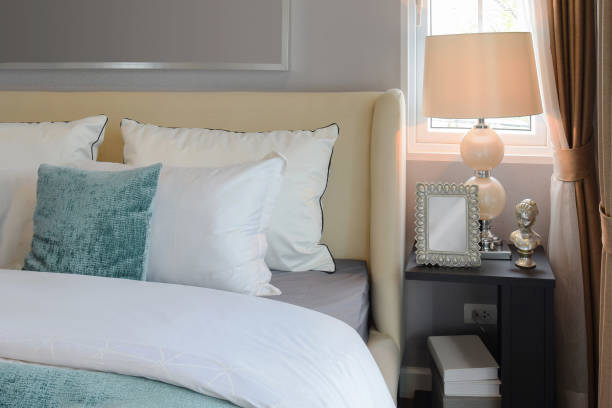 istock bedroom interior design with white and green pillows on white bed and decorative table lamp. 675295394