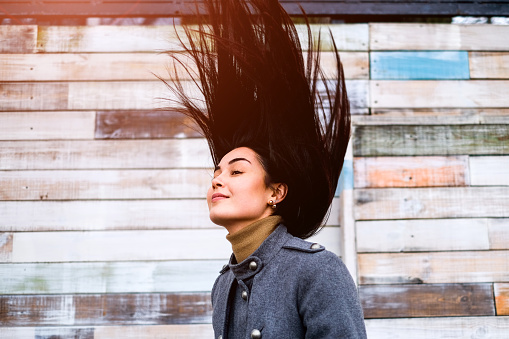 Young brunette woman outdoor with blowing up hair