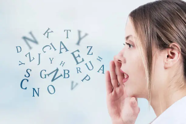 Photo of Woman talking with alphabet letters coming out of her mouth. Communication concept