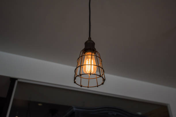 istock Decorative vintage style Edison type glowing light bulb in the modern interior 675301754