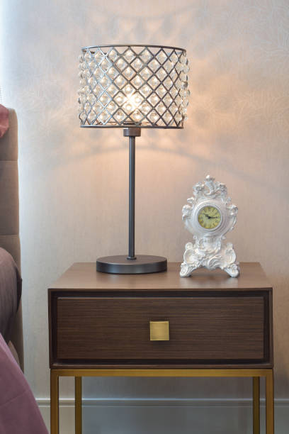 istock crystal reading lamp and classic clock on bedside table in cozy bedroom interior 675303816