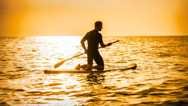 istock Man kneeling on a paddle board at sea 675304710