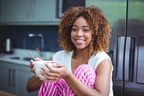 istock Happy woman having breakfast in kitchen 675314414