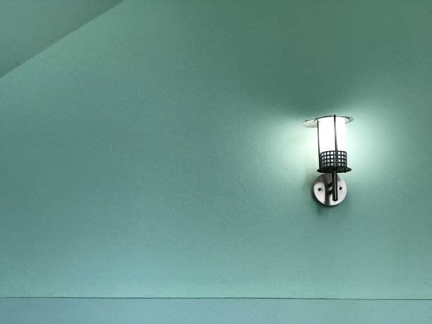 istock Black metal lamp on green wall 675314458