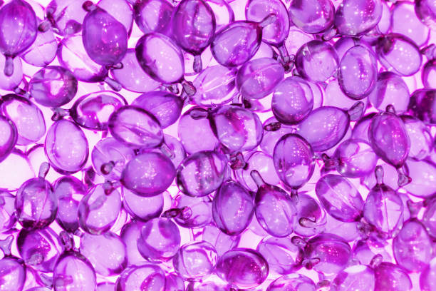 capsule di siero vitaminico per capelli e pelle in contenitore. - pill purple capsule vitamin pill foto e immagini stock