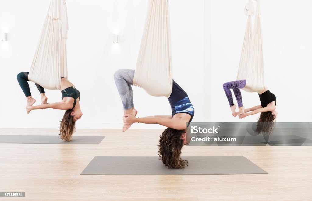 Aerial yoga class Women practicing aerial yoga Yoga Stock Photo