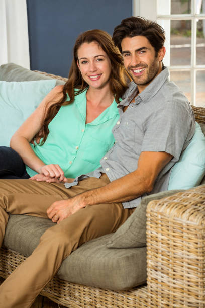 istock Young couple sitting together in sofa 675318468