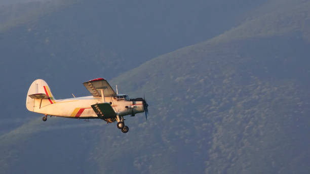 istock Crop duster spraying crops from the air in the morning light. Side view 675324476