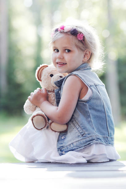 istock Girl playing with teddy bear 675326786
