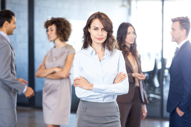 istock Businesswoman smiling at camera while her colleagues discussing in background 675327862