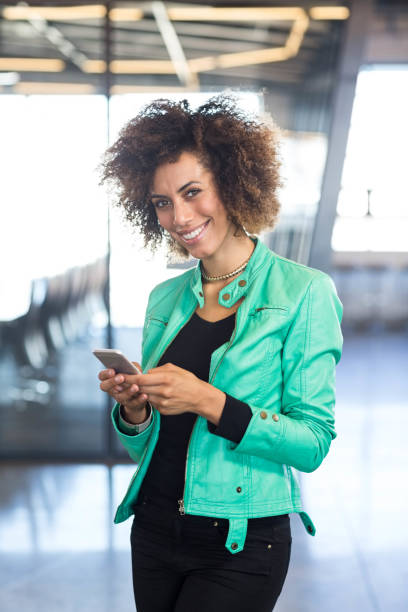 istock Young woman using mobile phone in office 675330512