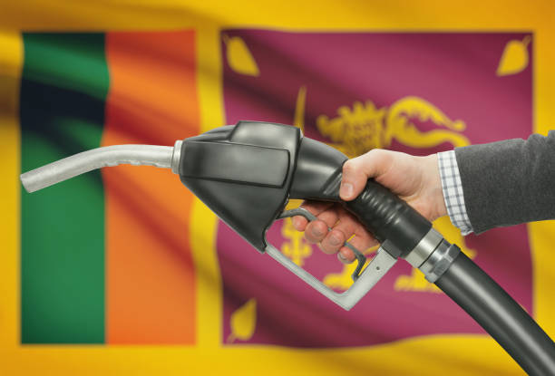 Fuel pump nozzle in hand with national flag on background - Sri Lanka stock photo