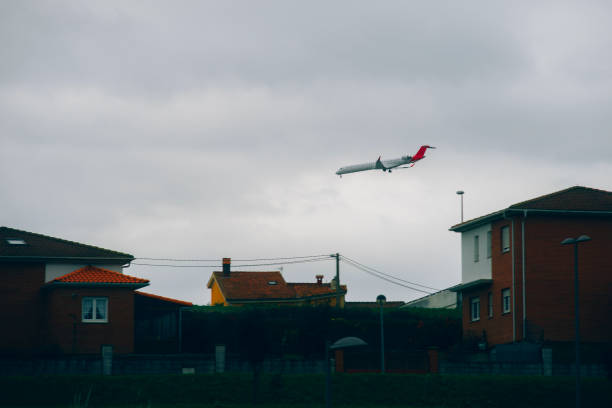 An airplane over some houses.