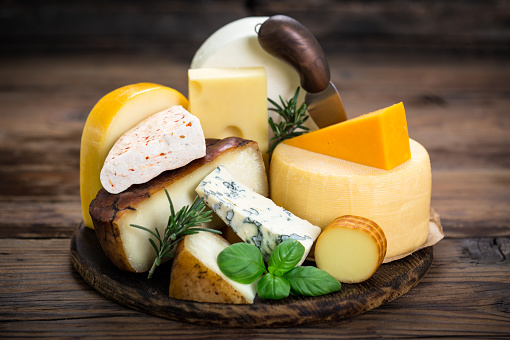 Various types of cheese on the wooden table