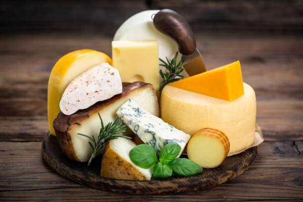 Various types of cheese on the wooden table stock photo