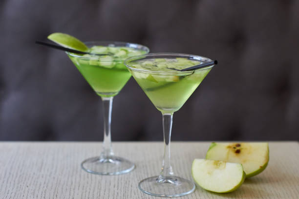 Two glasses of apple martini Two glasses of apple martini and apple slices on table in cafe green apple slice overhead stock pictures, royalty-free photos & images