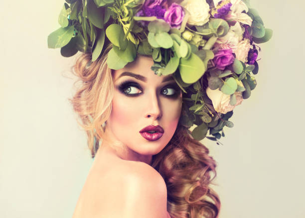 Lady Spring. Fresh flower wreath on the head of graceful, young woman woman.Makeup smokey eyes style and bright burgundy lipstick.