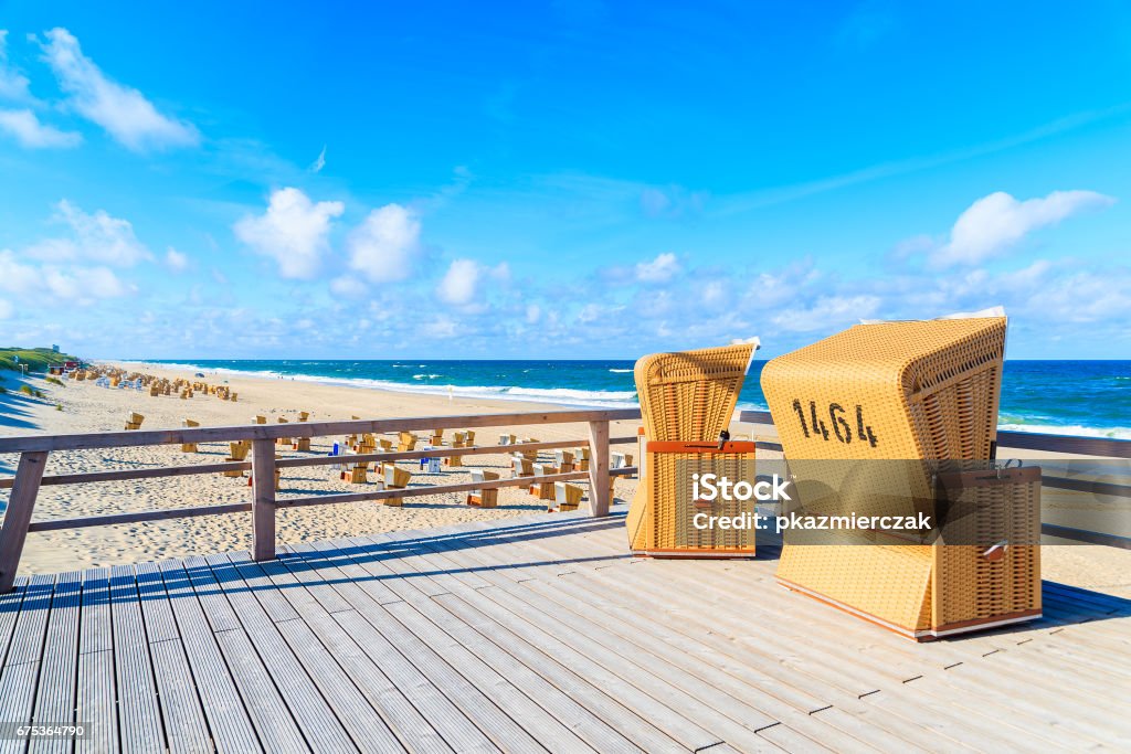 Wicker chairs on wooden terrace on beach in Wenningstedt village on Sylt island, North Sea, Germany Sylt is the largest North Frisian island and is a popular destination for fine food and water sports. Located off Schleswig-Holstein's North Sea coast. Island of Sylt Stock Photo