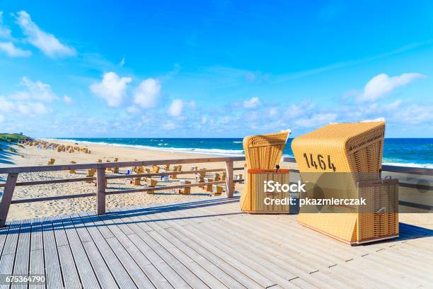 Wicker Chairs On Wooden Terrace On Beach In Wenningstedt Village On Sylt Island North Sea Germany Stock Photo - Download Image Now
