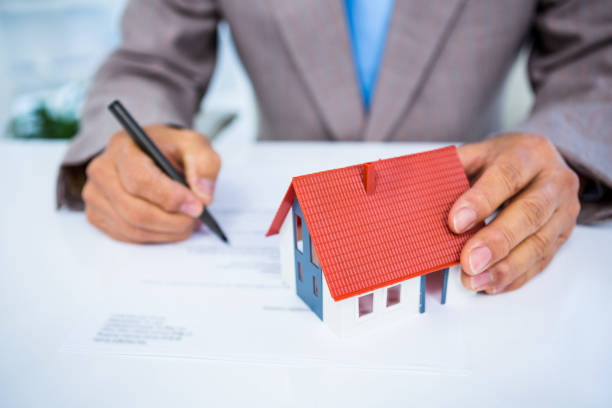 istock Businessman taking notes with miniature house 675368444