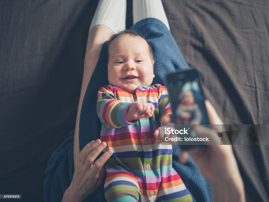 Mother taking photo of her baby A mother is using her smartphone to take a photo of her baby Photographing Stock Photo