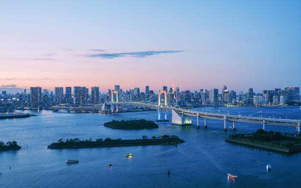 tokyo rainbow bridge se eleva sobre la bahía del puerto futurista ciudad de japón - bahía de tokio fotografías e imágenes de stock