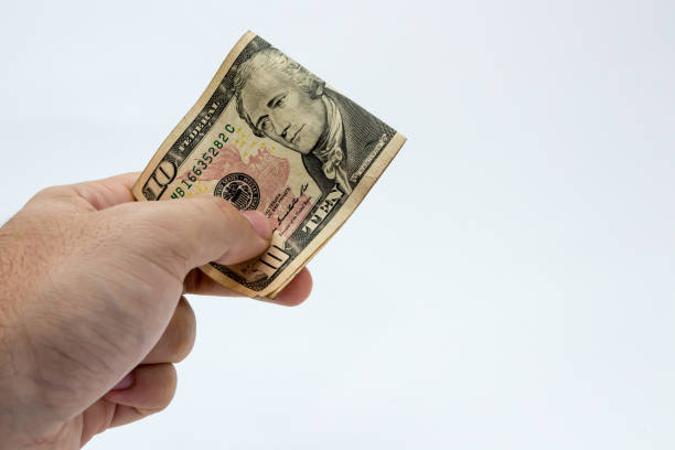 istock An image of a Caucasian male hand holding a twenty Dollar(USA) note with a plain background. 675386342