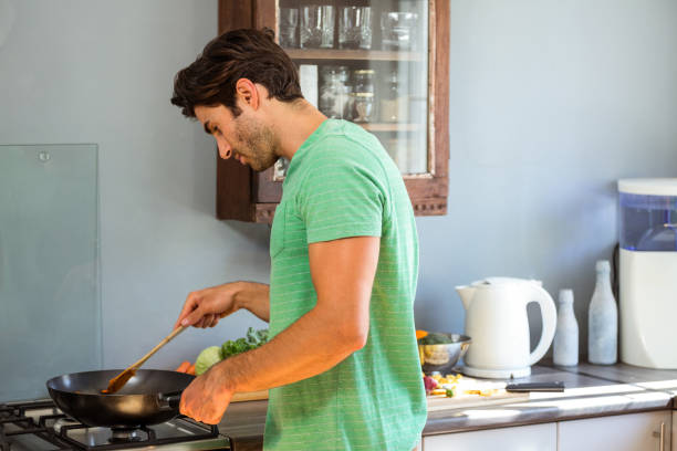 istock Man preparing food in kitchen 675392172