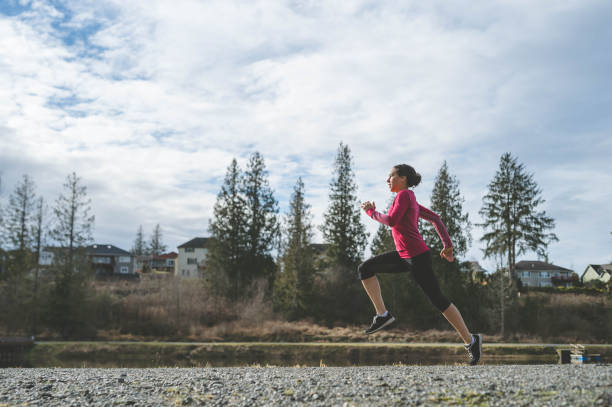 istock Young Eurasian woman jogging by lake 675409706