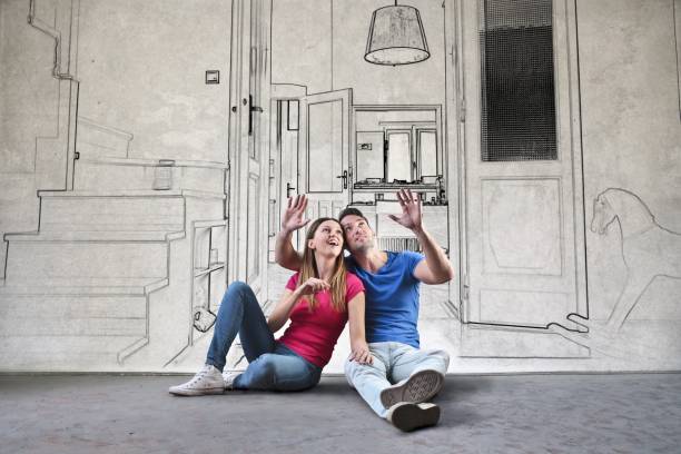 Planning the dream home Young couple is sitting on the ground and planning their new home dreaming stock pictures, royalty-free photos & images