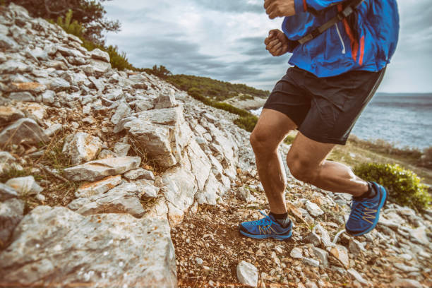 istock Man running up a hill at the sea 675410042
