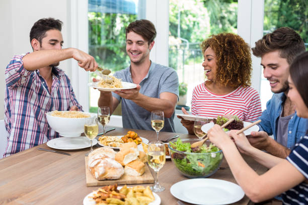 istock Friends having meal at table in house 675415528