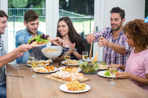 istock Multi-ethnic friends having meal at table in house 675415900