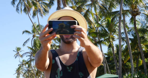 istock Man taking a selfie in a tropical beach 675426898
