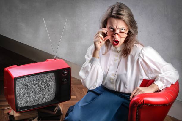 istock Woman with a retro TV 675446268