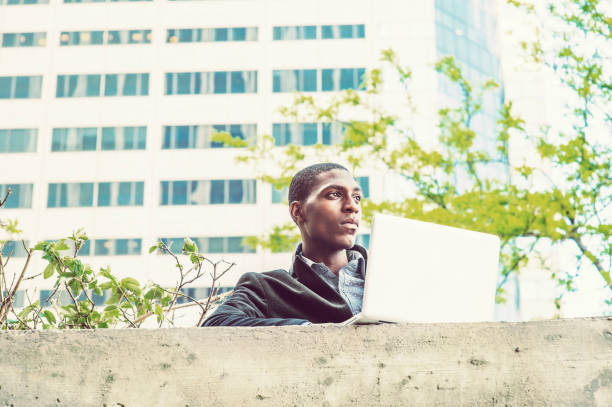 istock Young African American college student studying, working on laptop computer on campus in New York 675448982
