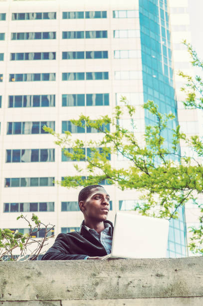 istock Young African American college student studying, working on laptop computer on campus in New York 675449006