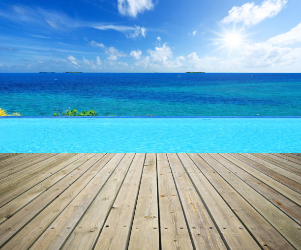 istock Wooden terrace beside infinity pool 675449166