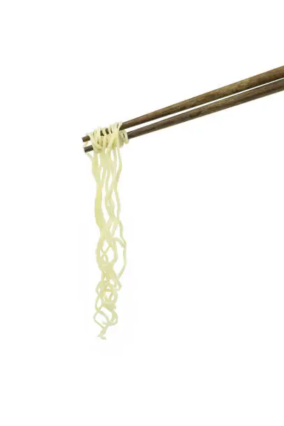 Photo of chopsticks holding oriental noodles isolated on a white background