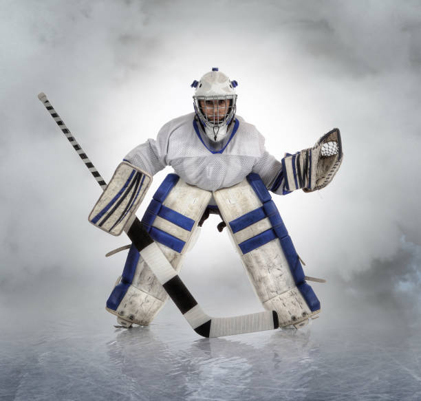 Young female hockey goalie. A young female ice hockey goalie in a ready position. teen goalie stock pictures, royalty-free photos & images